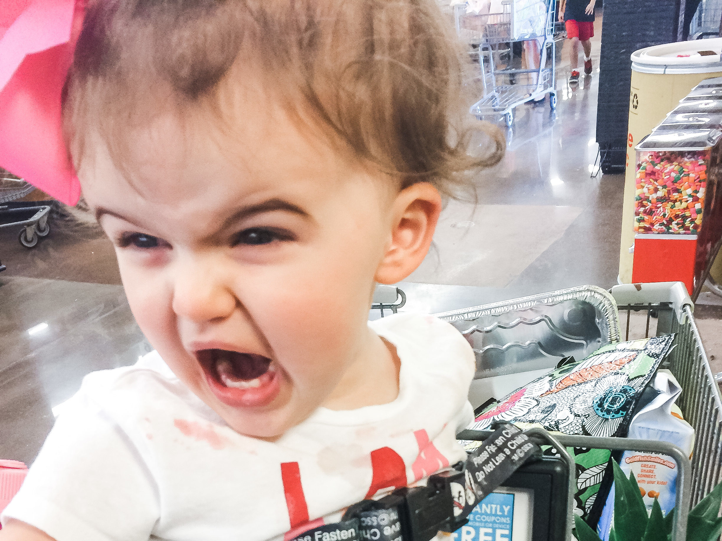 Screaming toddler with PANS/PANDAS in grocery cart throwing a tantrum